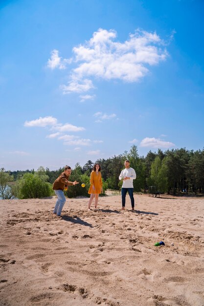 Full shot friends playing game on beach