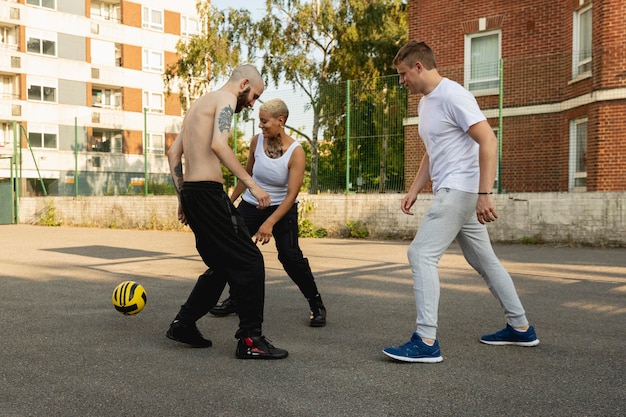 Free photo full shot friends playing with ball