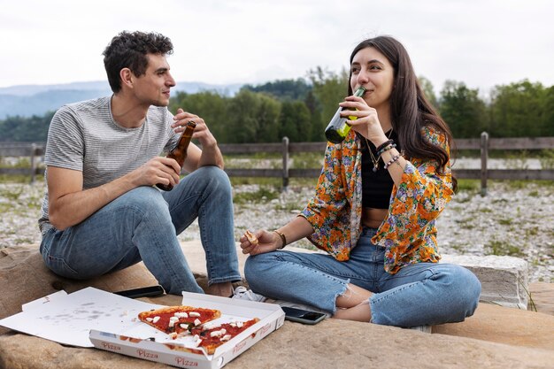 Full shot friends relaxing with drinks outdoors