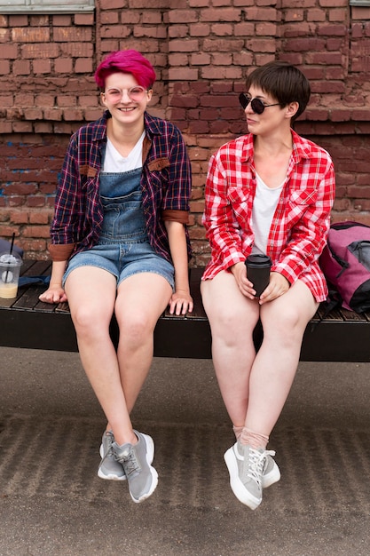 Full shot friends sitting on bench