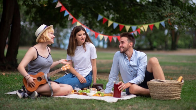 Free photo full shot friends sitting on cloth