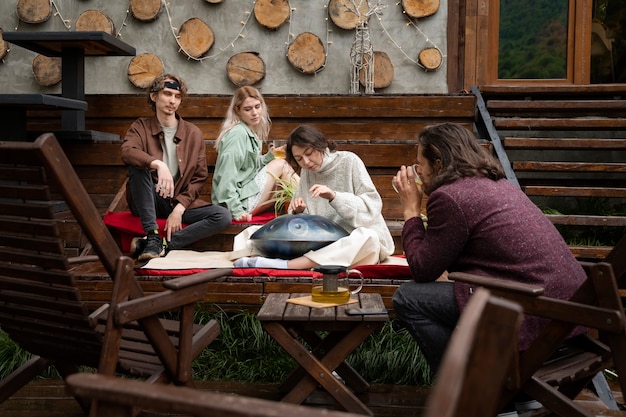 Free photo full shot friends sitting outdoors