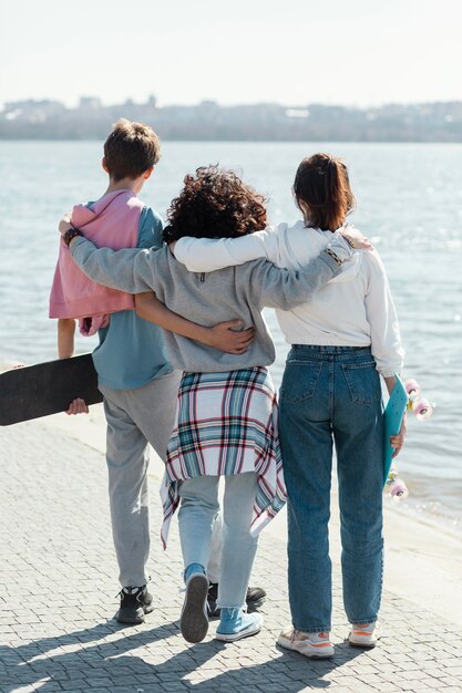 Full shot friends together at seaside