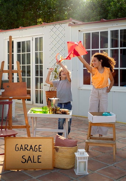 Free photo full shot girl and boy at garage sale