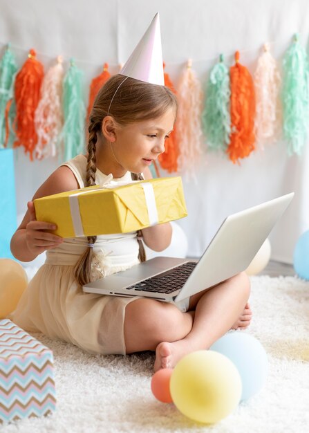 Full shot girl holding laptop on legs