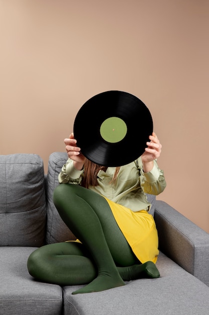 Free photo full shot girl holding vinyl disc