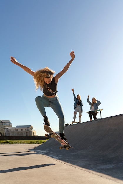 Full shot girl jumping with skateboard