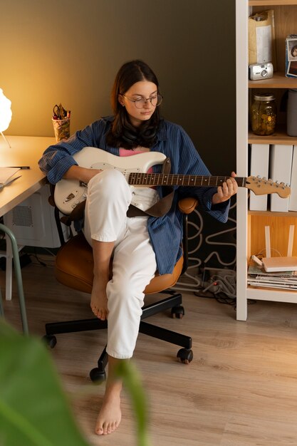 Full shot girl playing the guitar