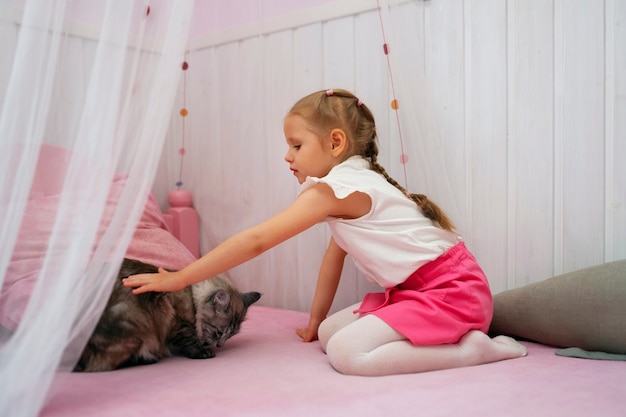 Full shot girl playing with cat