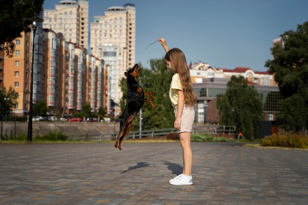 Full shot girl playing with dog