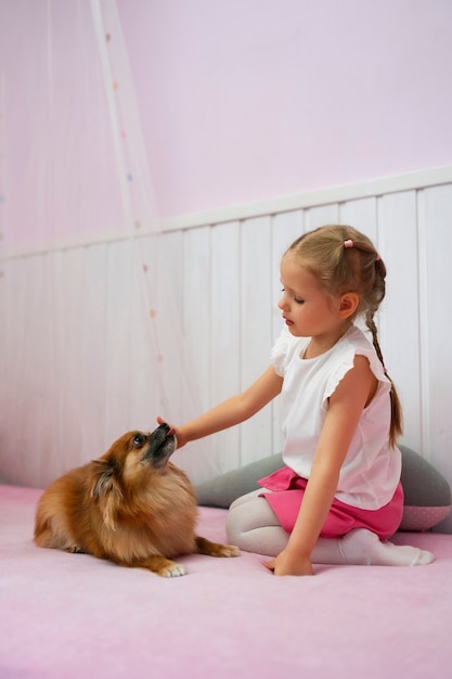 Full shot girl playing with dog