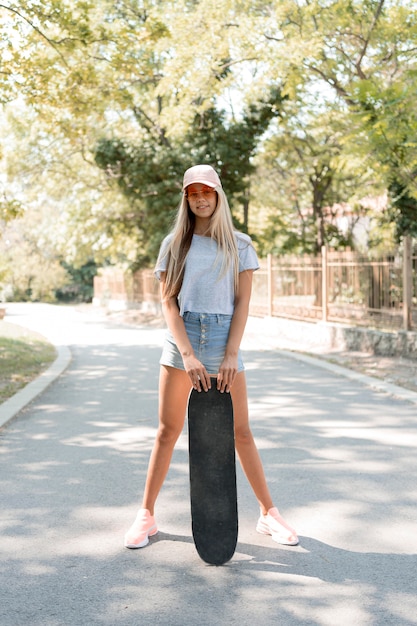 Full shot girl posing with skateboard