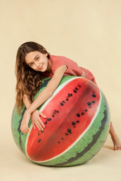 Free photo full shot girl posing with watermelon ball