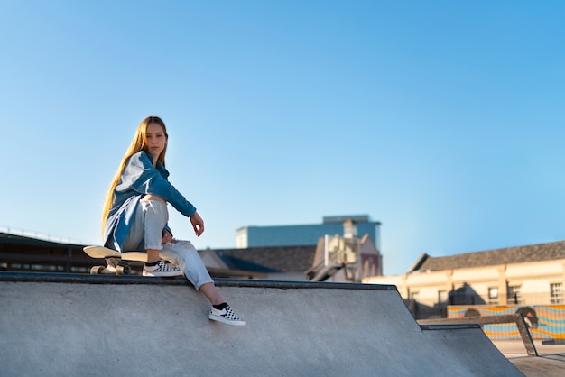 Free photo full shot girl sitting in skate park