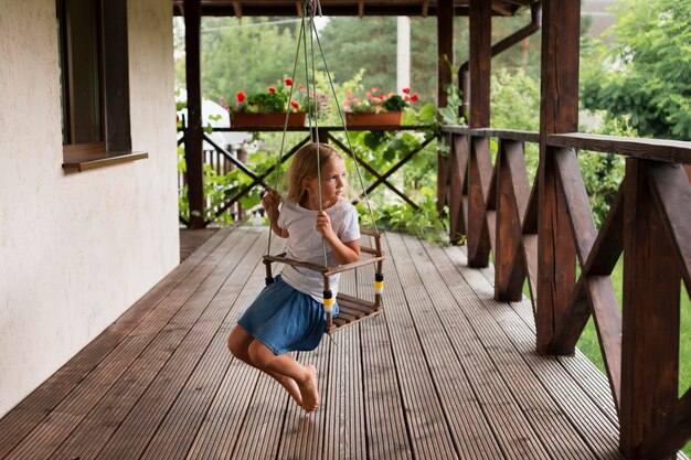 Full shot girl on swing