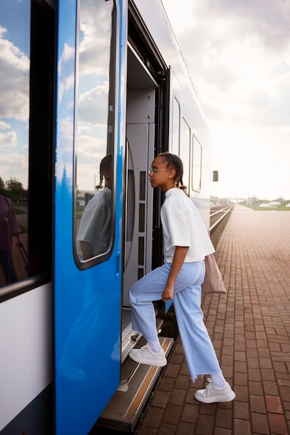 Free photo full shot girl traveling by train