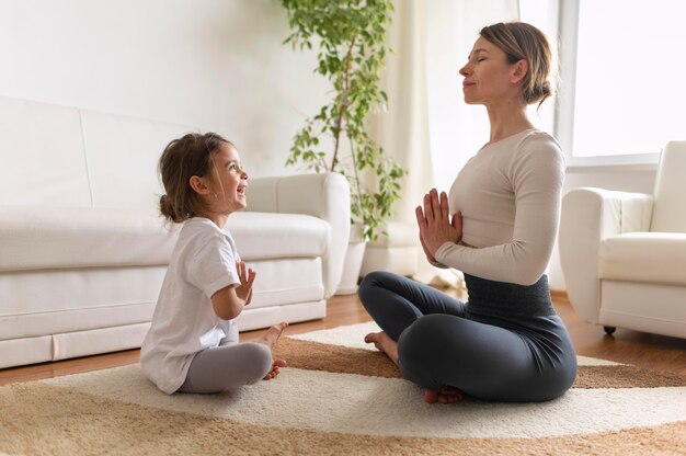 Full shot girl and woman meditating