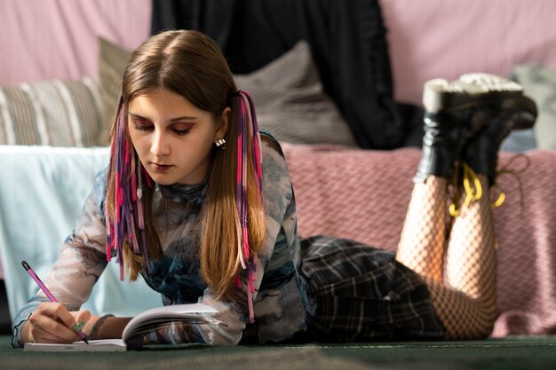 Full shot girl writing on floor