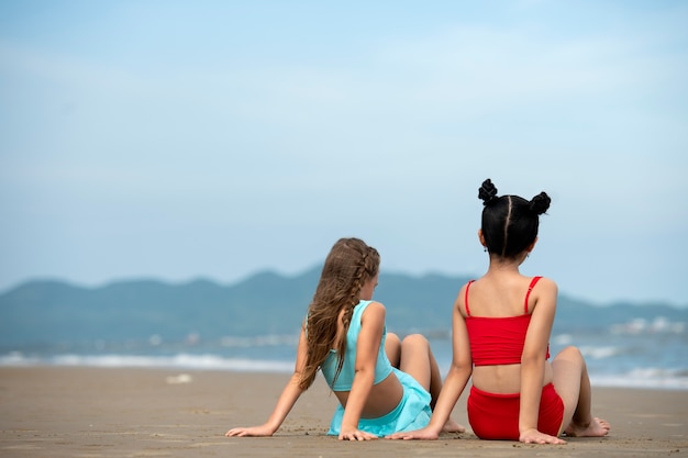 Full shot girls sitting on beach