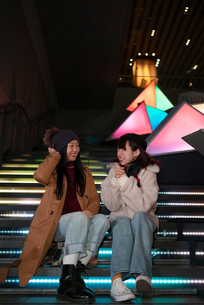 Free Photo full shot girls sitting on bench