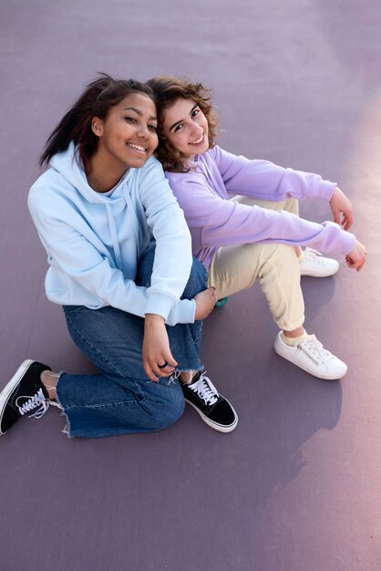 Full shot girls sitting outdoors