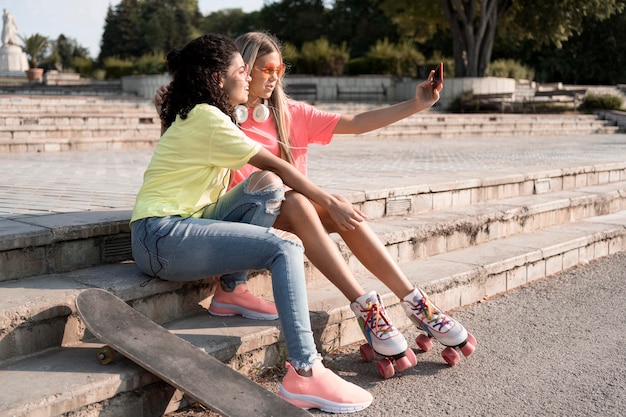 Free photo full shot girls taking selfie together