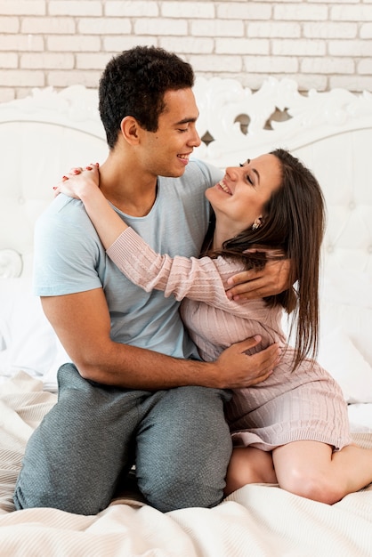 Free photo full shot happy couple hugging in the bedroom