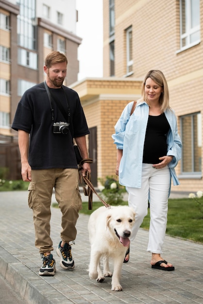 Full shot happy couple walking with dog