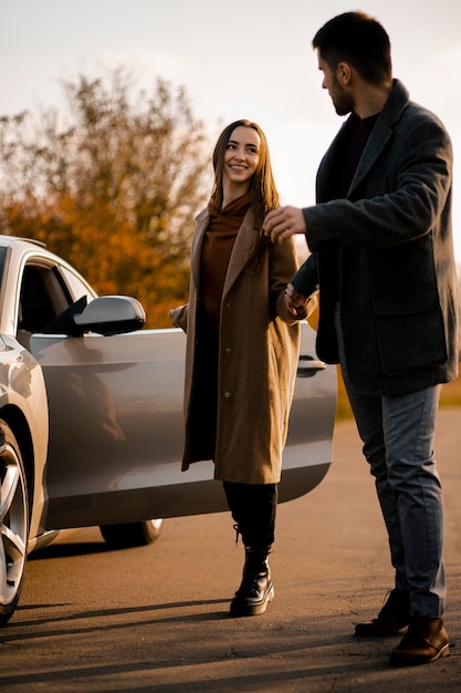 Free photo full shot happy couple with car