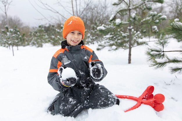 Full shot happy kid playing with snow