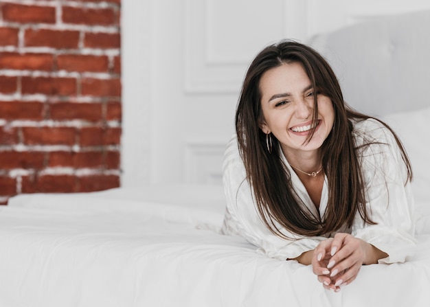 Full shot happy woman in bed