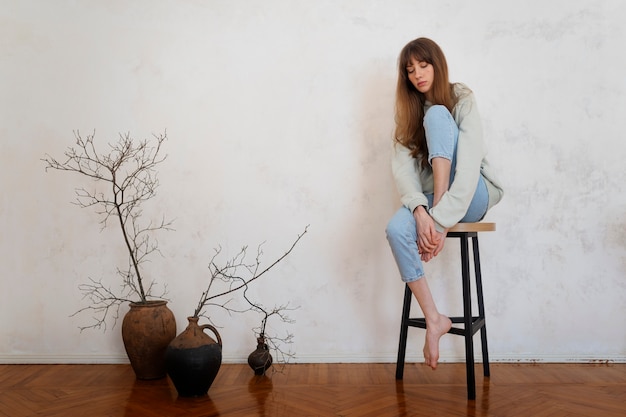 Free Photo full shot insecure woman on chair