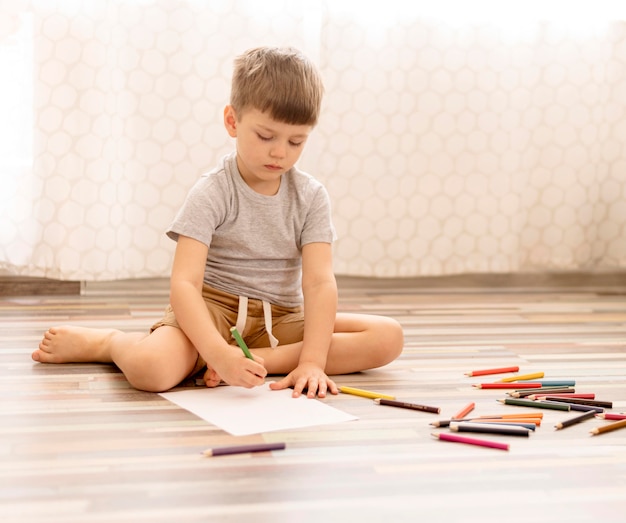 Full shot kid drawing on floor