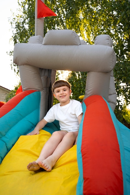 Full shot kid having fun in bounce house