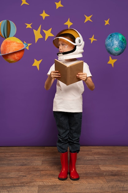 Free photo full shot kid holding book