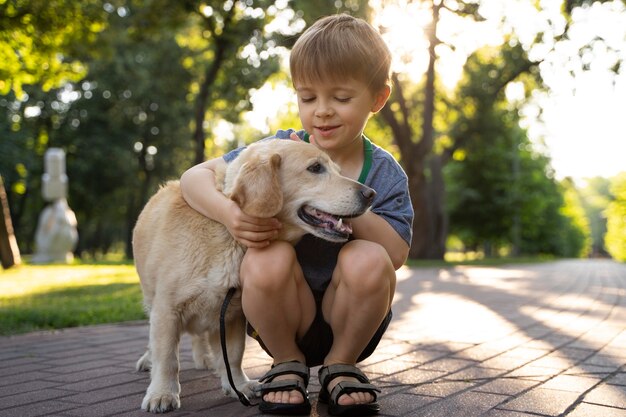 Full shot kid hugging dog in park