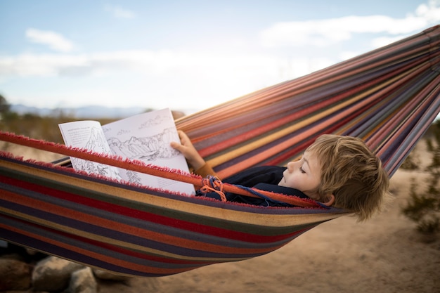 Free Photo full shot kid laying in hammock