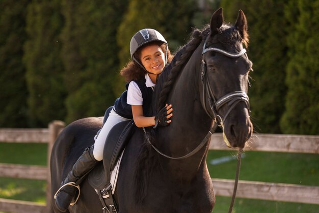 Full shot kid learning to ride horse