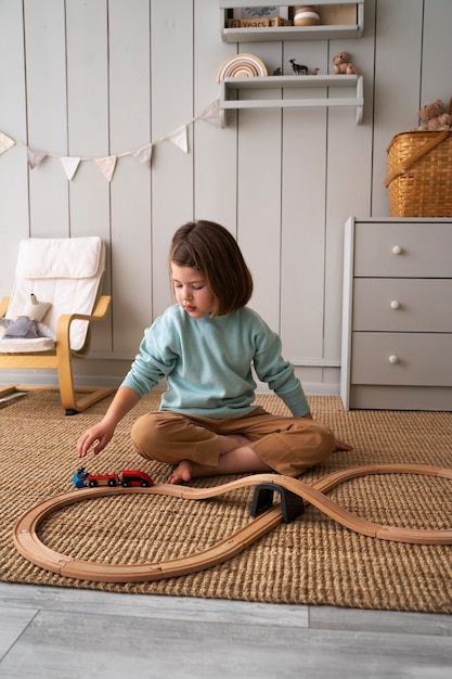 Full shot kid playing with train