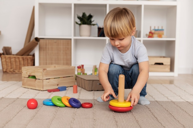 Free photo full shot kid playing with wooden toy