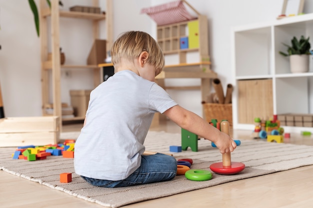 Full shot kid playing with wooden toys