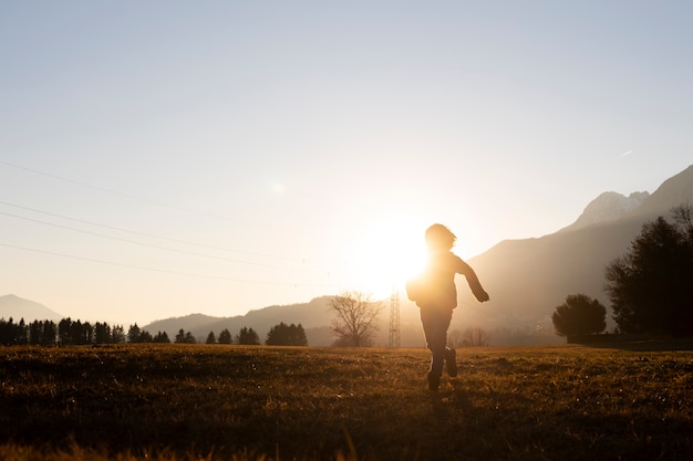 Free photo full shot kid silhouette running in nature