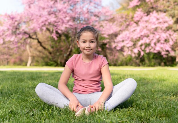 Full shot kid sitting on grass