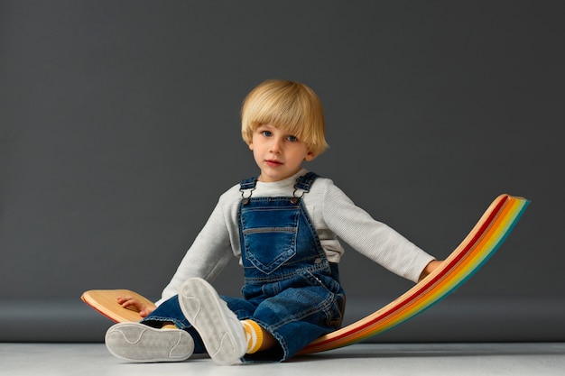 Free photo full shot kid sitting in studio