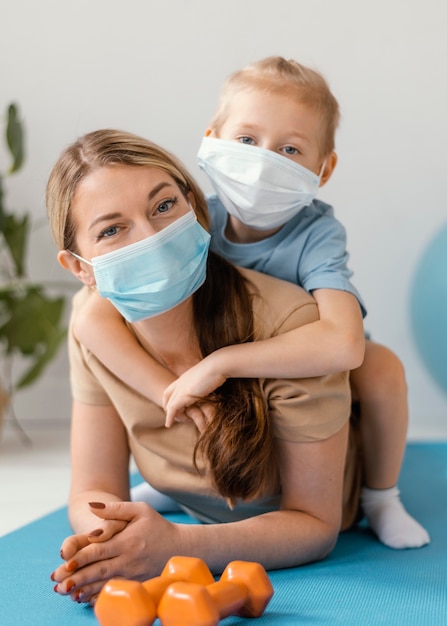 Full shot kid and woman wearing masks