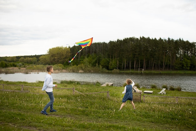 Free photo full shot kids flying a kite outdoors