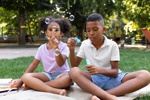 Full shot kids making soap bubbles