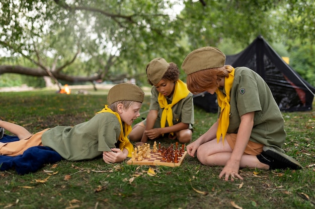 Free photo full shot kids playing chess