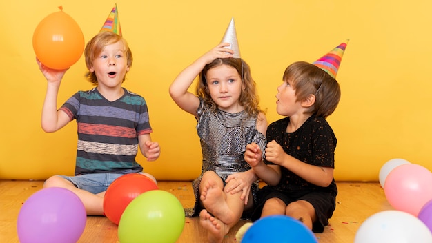 Free Photo full shot kids sitting on floor