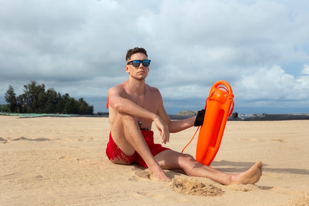 Free photo full shot lifeguard sitting on beach